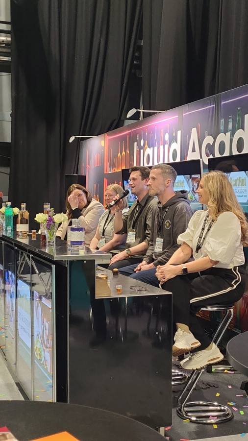 A tasting panel seated at the Liquid Academy Live bar
